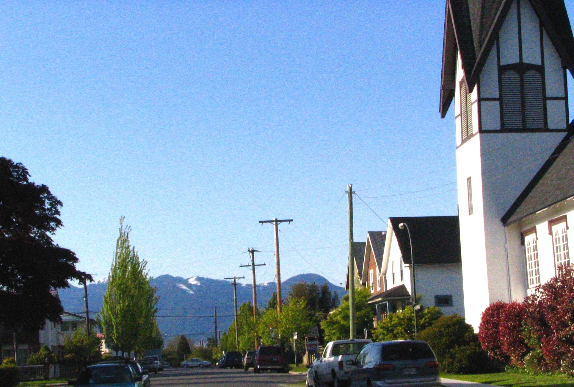 Street and houses in the Dickens neighbourhood of East Vancouver (with North Shore Mountains in background)