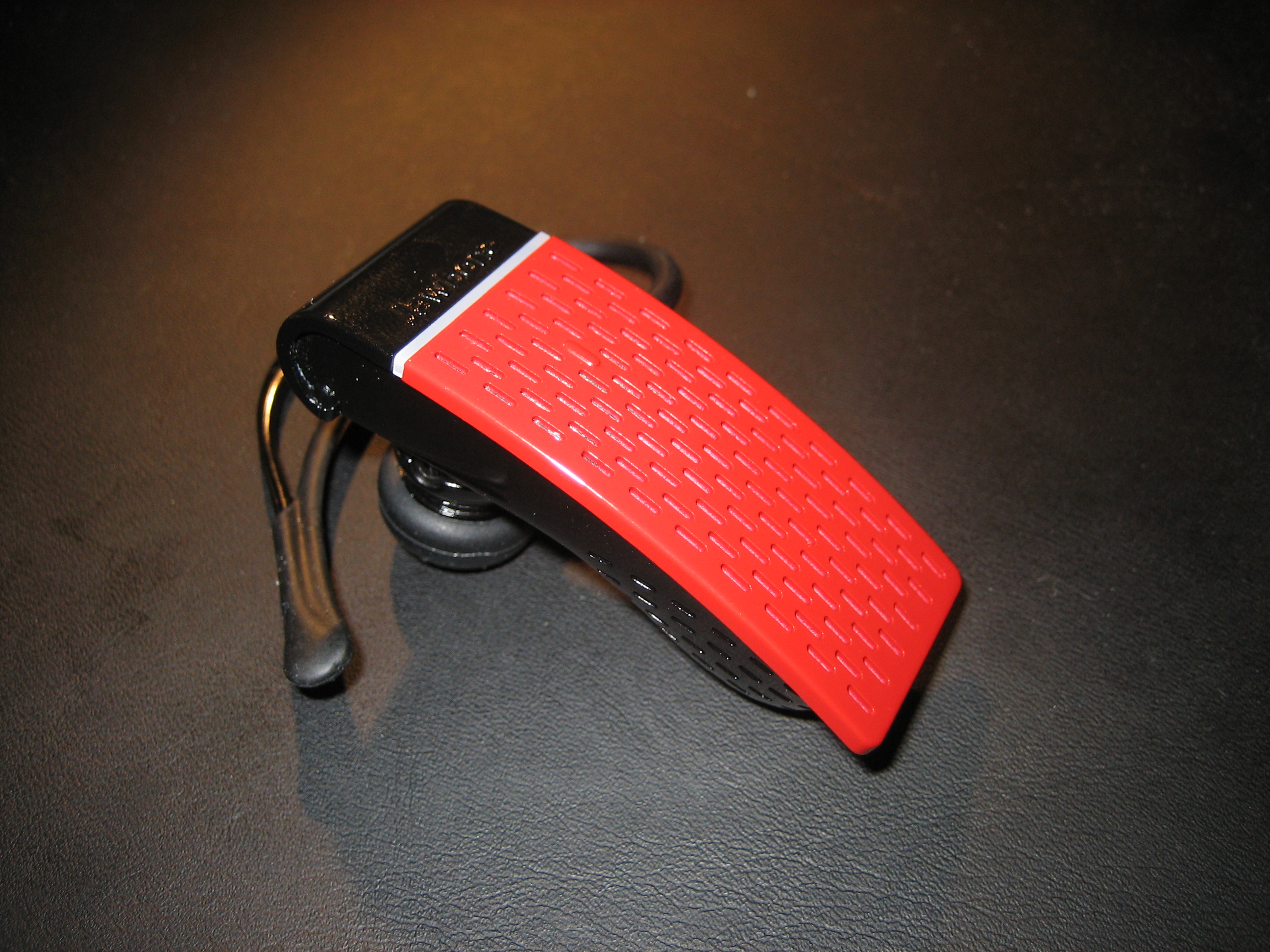A red Jawbone Bluetooth Headset.