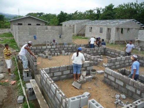 Villagers laying bricks for the foundation of a house