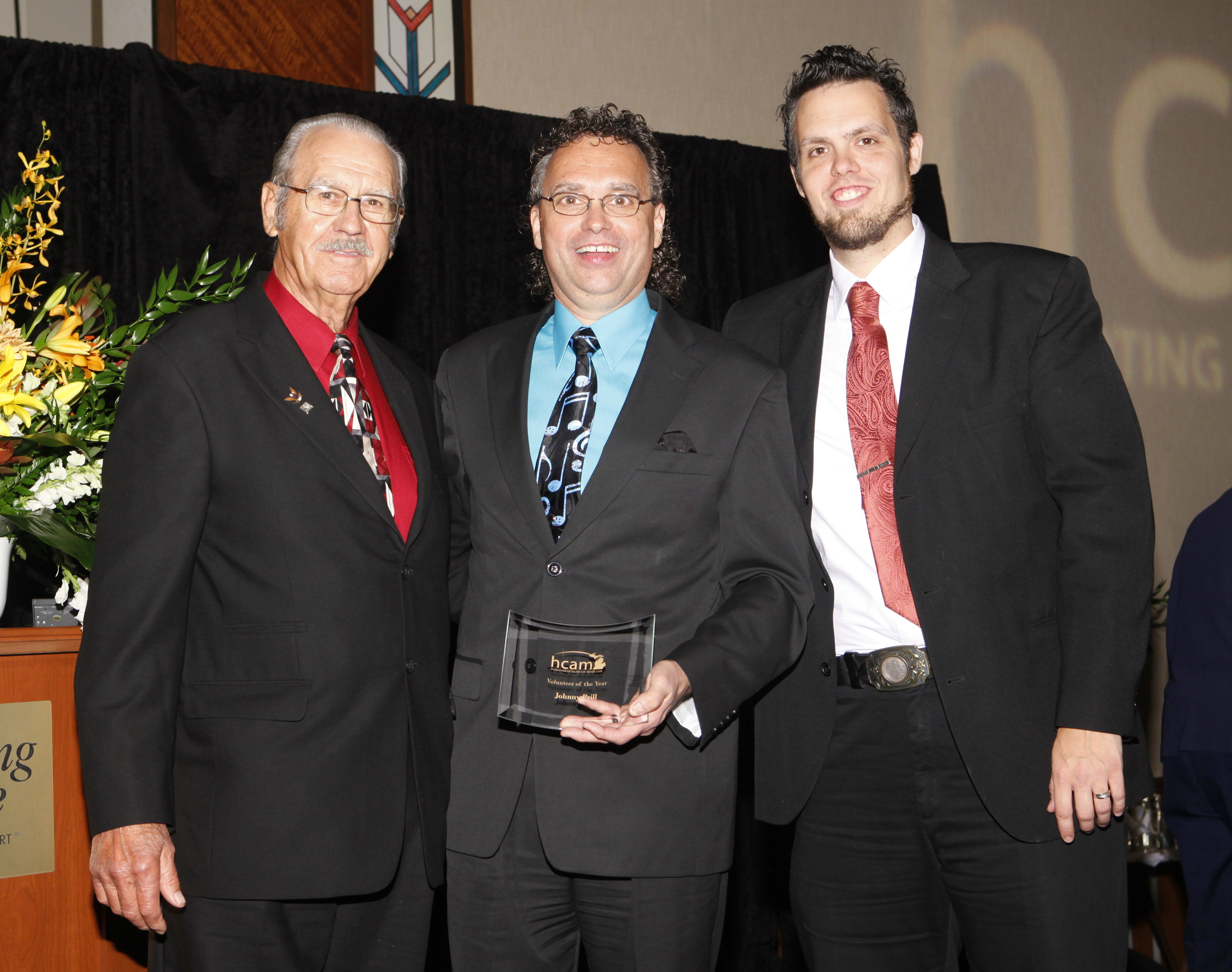 Johnny Prill, with band members John Prill Sr. and Christopher Prill, at the Health Care Association of Michigan award ceremony. Prill received their â€œVolunteer Of The Year Award."