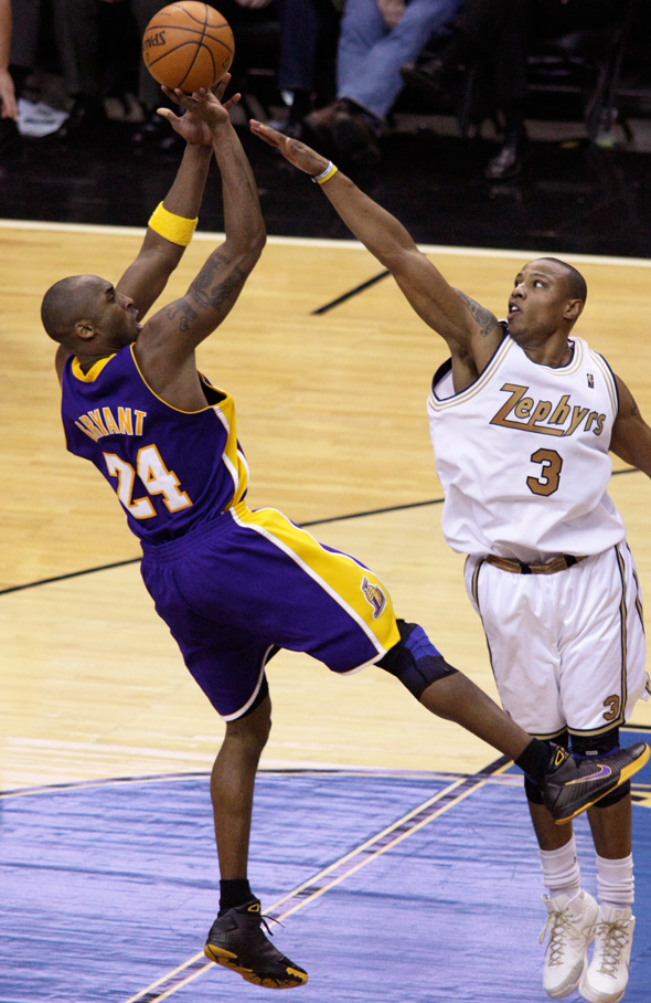 Kobe Bryant scored 50 points or more in four consecutive games in 2007.|alt=A black basketball player, wearing a jersey with a word "BRYANT 24" on the back, tries to shoot a ball behind another black player, wearing a jersey with a word "ZEPHYRS 3" in the front.