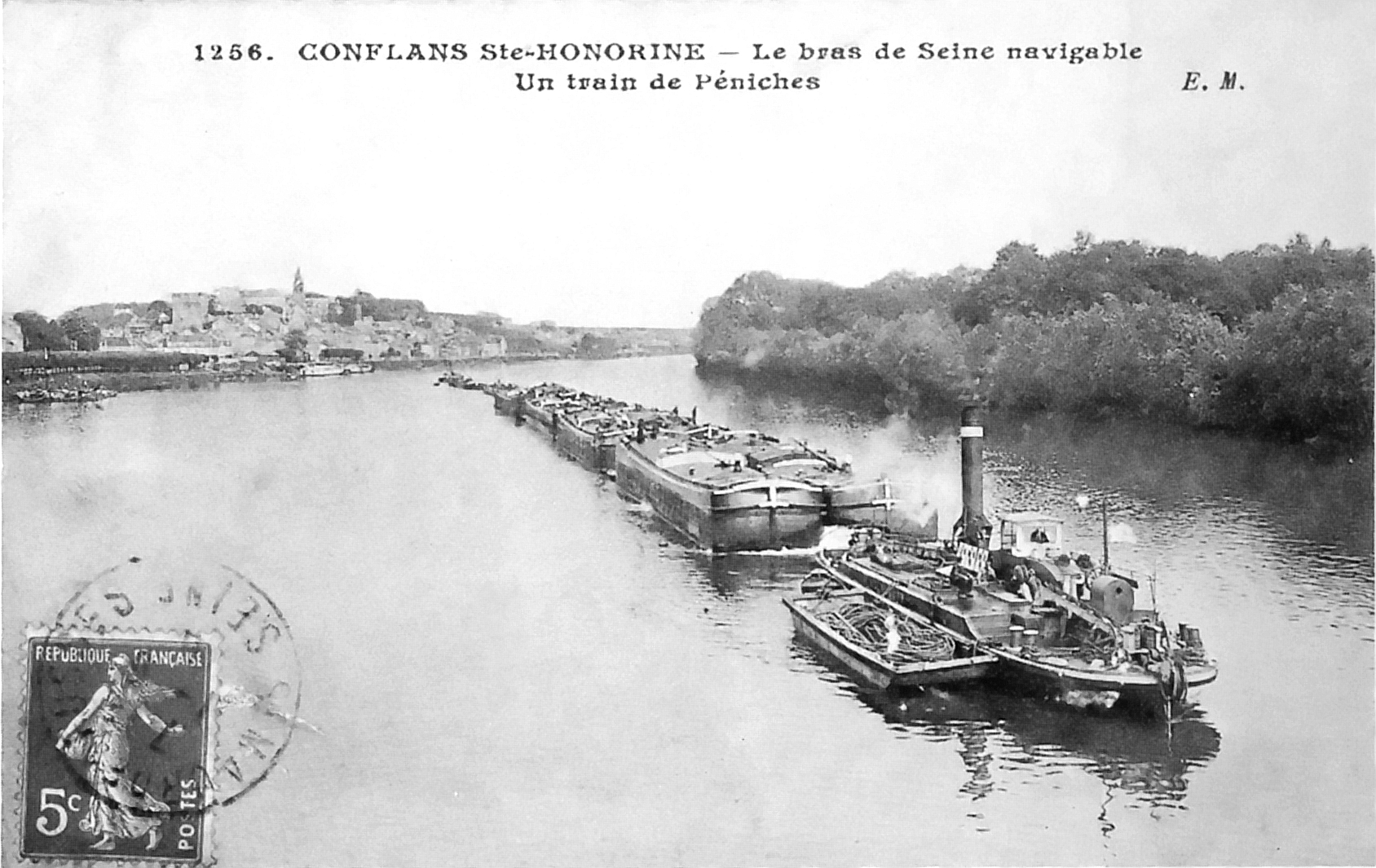 Chain steamer on the Seine hauling a train of barges