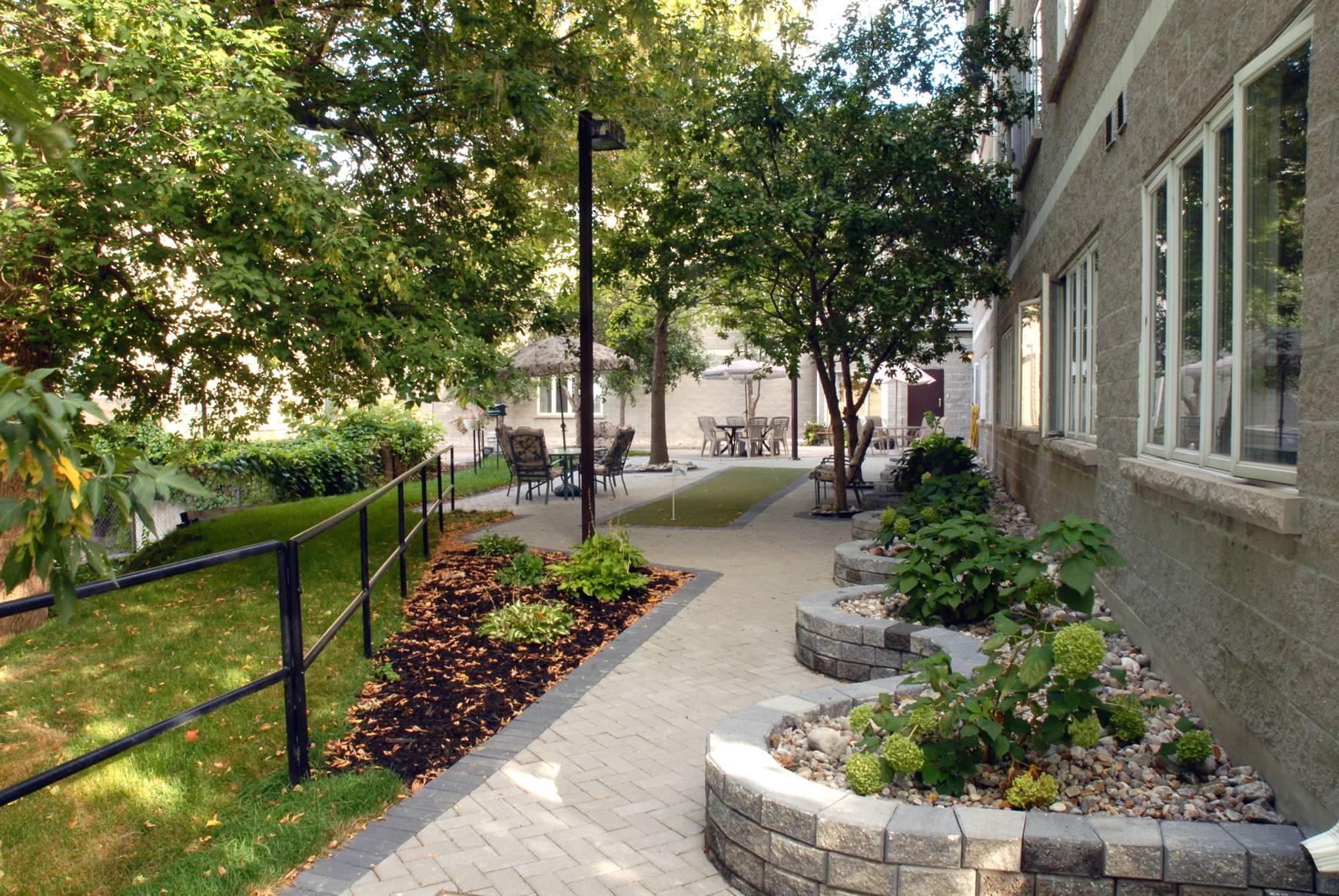 text| A shot from the back garden of the Bridge Street Retirement Residence, taken facing the original Parish Hall structure
