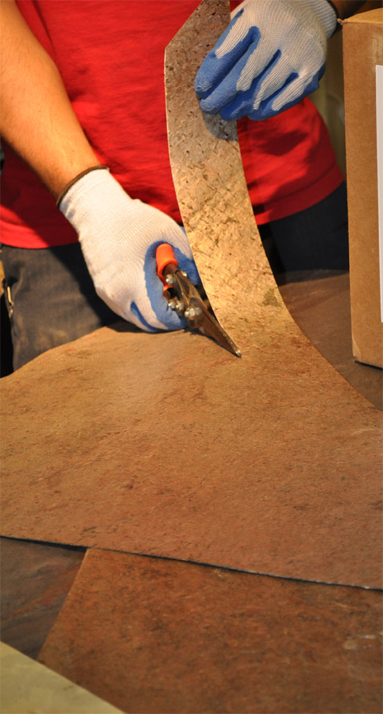 A sheet of flexible stone veneer being cut and bent A sheet of flexible stone veneer being cut and bent