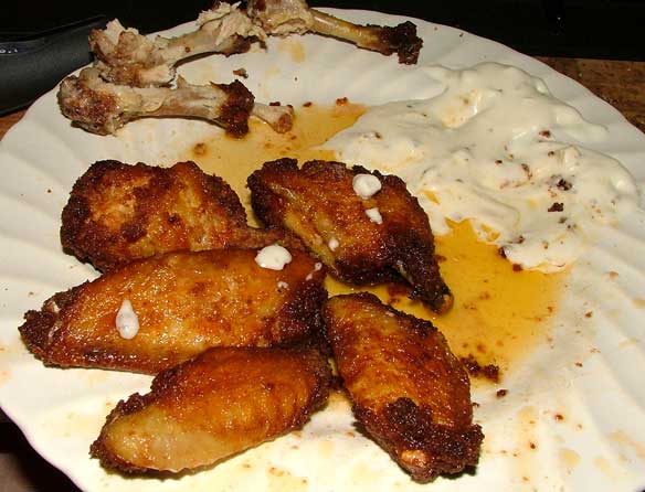 Buffalo Wings, coated in Italian bread crumbs, deep fried, with butter, vinegar, and Tabasco hot sauce and chunky bleu cheese dressing dipping sauce