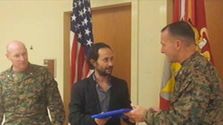 Musoso receives an award from the Commander of the U.S Marines