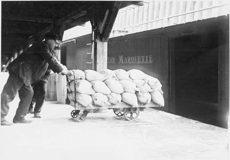 Loading salt into a Pere Marquette Railway freight boxcar for shipping and transporting