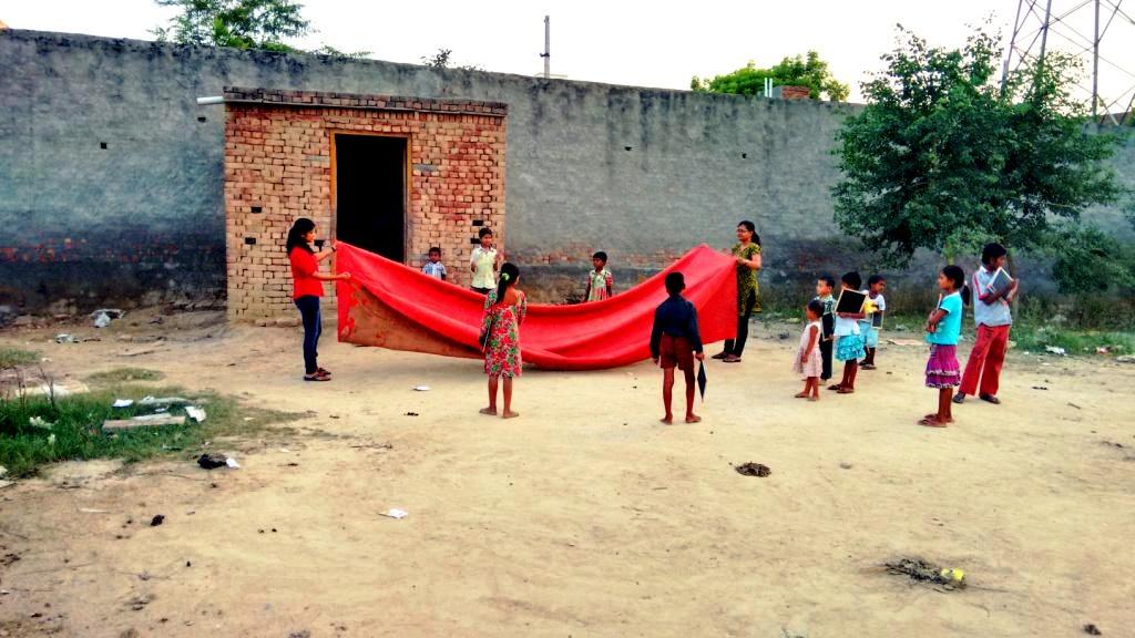 Purna Shiksha's first-day school in open ground conducted by two volunteers Purna Shiksha's first-day school in open ground conducted by two volunteers