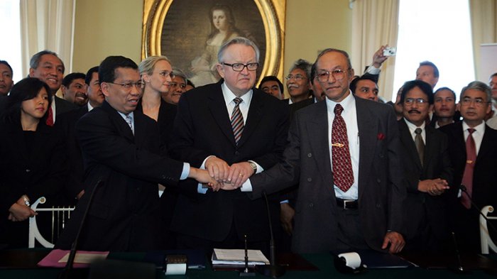 Hamid Awaluddin and Malik Mahmud shake hands after signing the Helsinki Agreement mediated by the former President of Finland, Martti Ahtisaari.