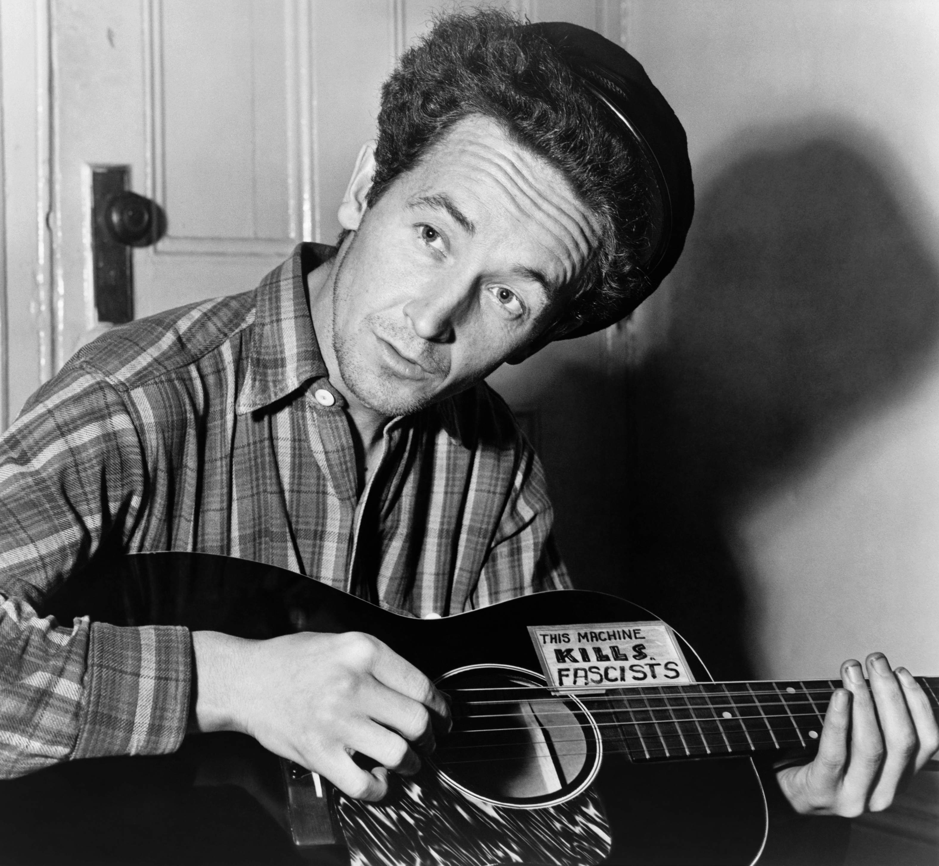 Folk singer Woody Guthrie was well known for playing a guitar with a paper sticker reading "This Machine Kills Fascists," an ironic adaptation of a slogan originally painted on Loyalist aircraft during the Spanish Civil War.