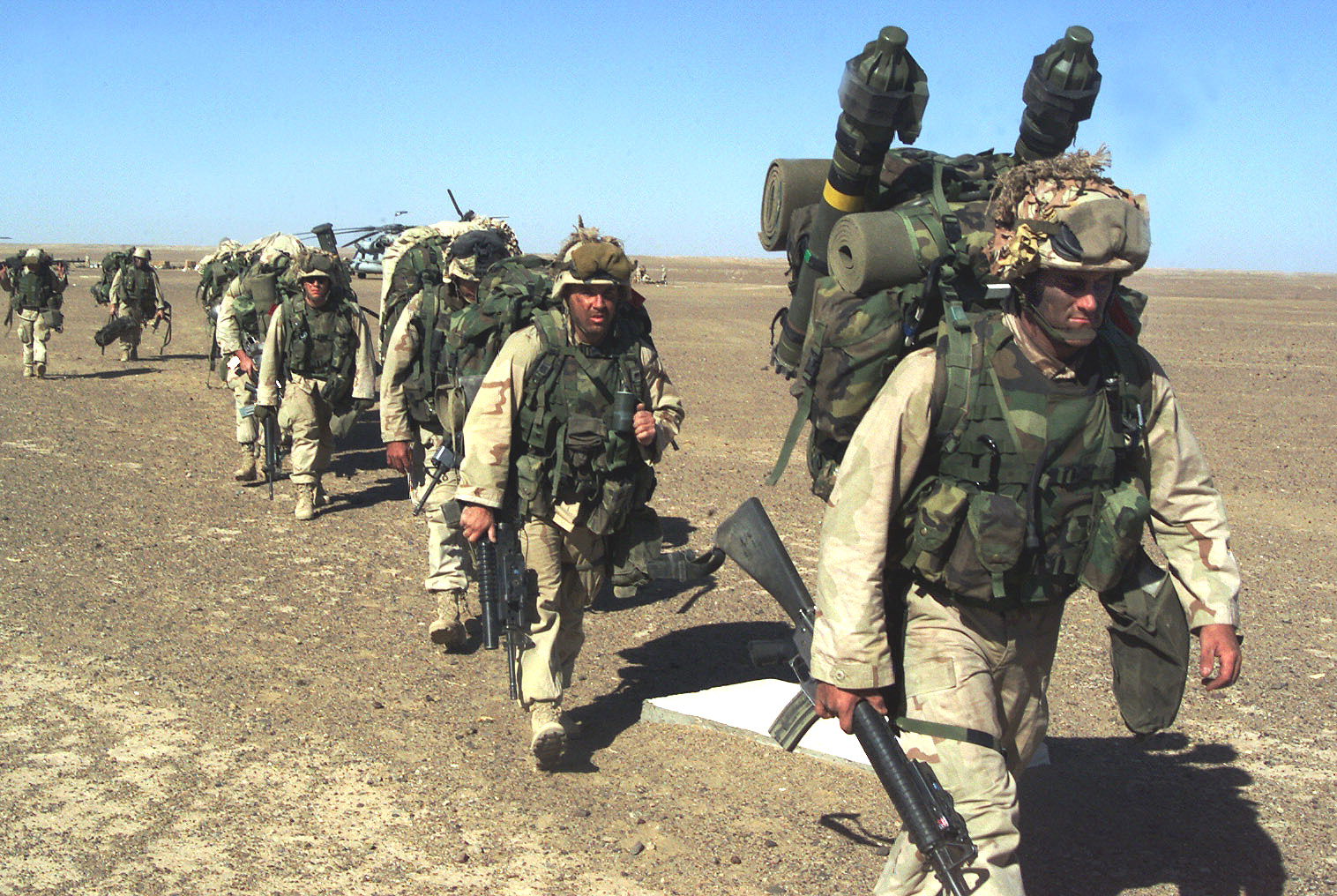SOUTHERN AFGHANISTAN–A Marine with the 15th Marine Expeditionary Unit (Special Operations Capable) leads a platoon of leathernecks to a security position after seizing a Taliban forward-operating base November 25, 2001.––photo by Sgt. Joseph R Chenelly